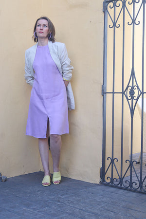 Frau mit knielangem Kleid in Lavendel und hellem Leinen Blazer