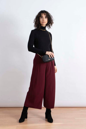 dunkelrote Culotte weite Hose 7/8 Damen mit schwarzem Pullover, Handtasche von Amelie Zürich