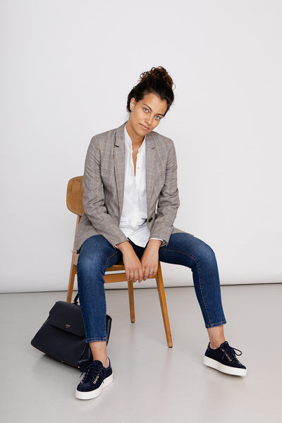Jeans aus Bio-Baumwolle dunkelblau Damen eng mit weißer Bluse und grauem Blazer, Handtasche von Amelie Zürich