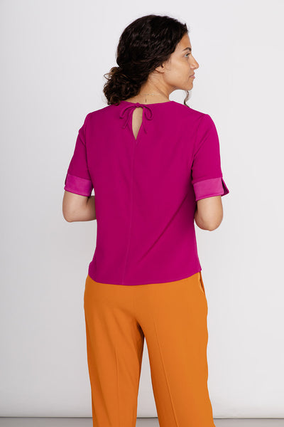 Shirtbluse kurzer Arm Damen aus Lyocell in pink mit oranger Anzughose Rückansicht mit Bindedetail