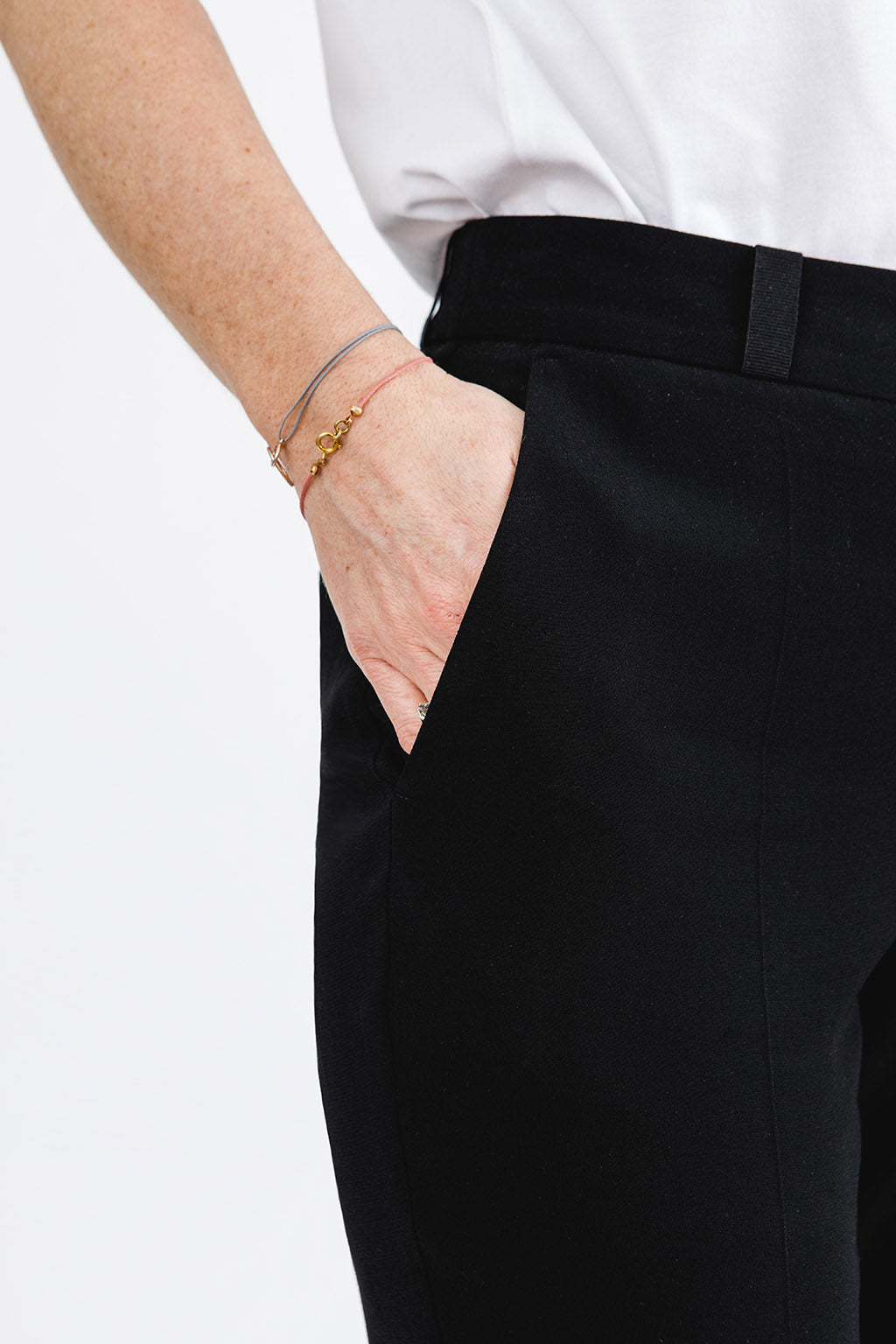 schwarze Anzughose schmales Bein Damen mit weißem Shirt Detailansicht Hosentasche