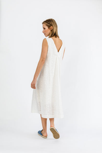 Model mit weißem besticktem Kleid mit V-Rücken